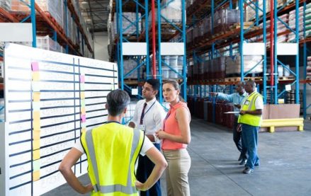 Warehouse staff talking in front of whiteboard