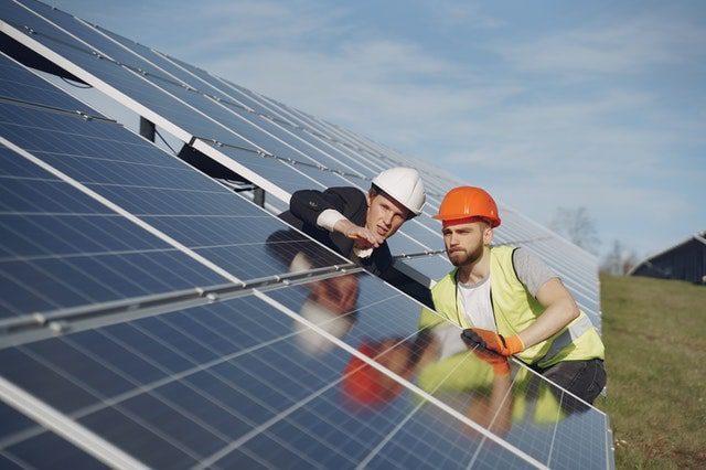 Maintenance workers inspecting solar panels