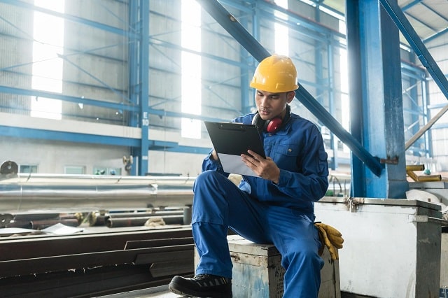 Worker documenting OEE metrics in a manufacturing facility