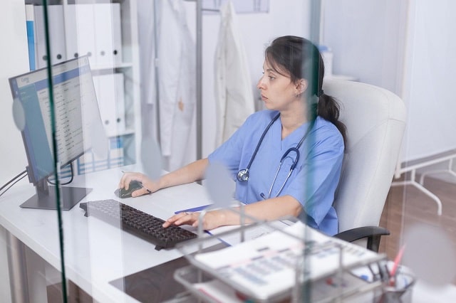 Nurse working on computer system in a hospital