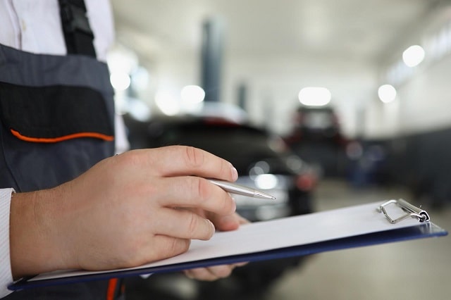 Technician using a preventive maintenance schedule to check off maintenance tasks