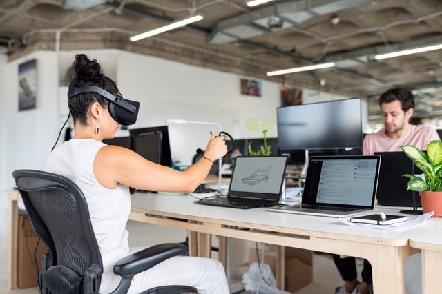 Employees using VR and computers in an office