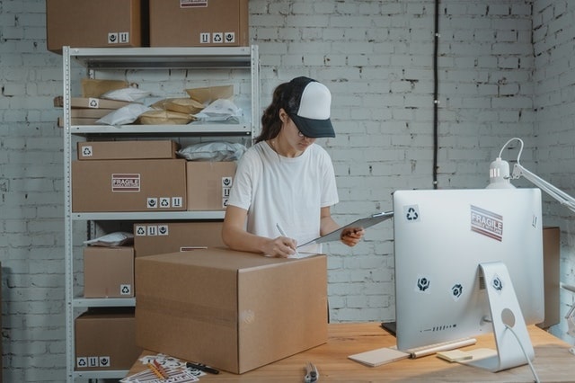 Woman working on warehouse receiving with computer software