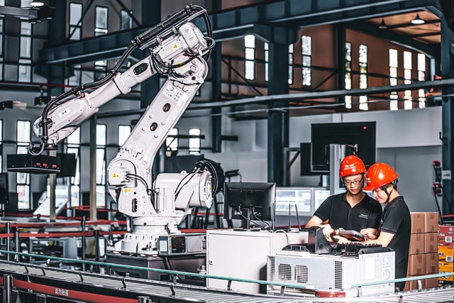 Workers and robot in an industrial plant