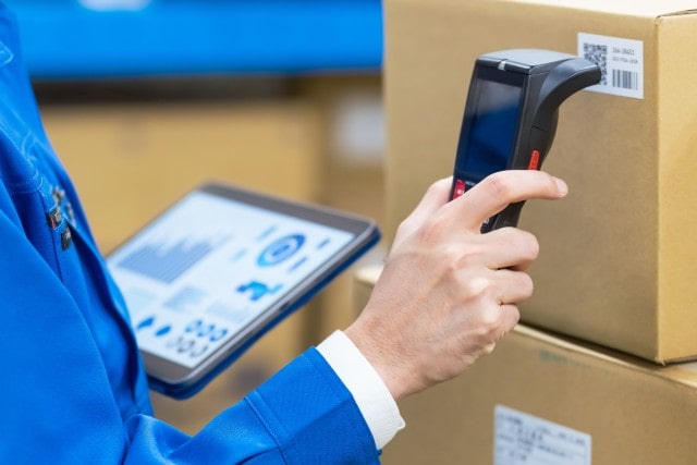 Person scanning a QR code on a box