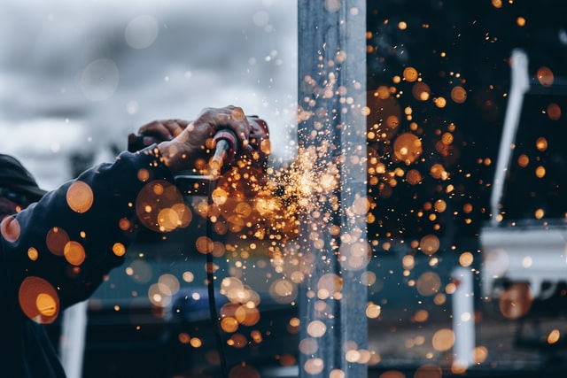 Worker using a tool to perform maintenance activities in a facility