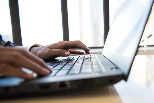 Person typing on a laptop keyboard