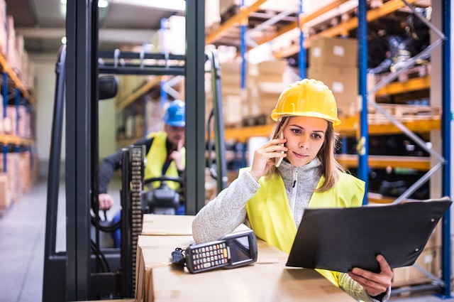 Warehouse manager on phone while viewing data on a tablet