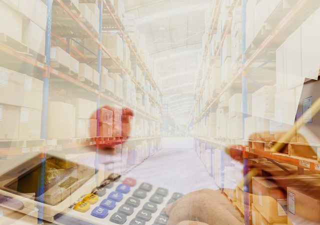 Warehouse background with a calculator in the forefront representing cost control