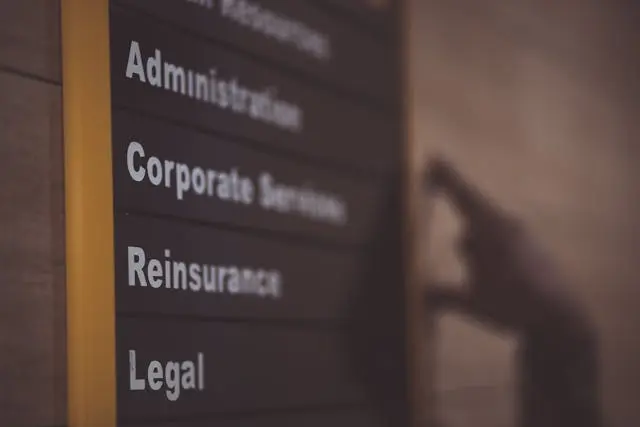 Close-up of a board on a wall showing the different departments in an organization