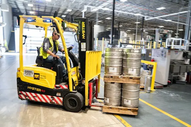 A yellow forklift being driven in a warehouse