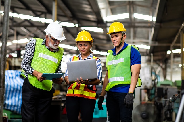 Workers and managers reviewing asset and MRO data in a centralized asset database