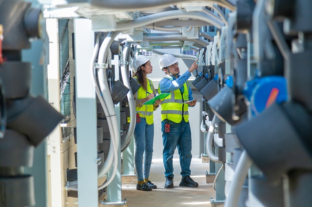 Workers  checking asset serial numbers in a beverage factory