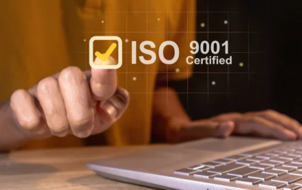 Person selecting an ISO 9001 certified checkmark icon on a digital interface, representing quality management system certification